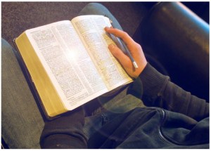 reading Bible in chair